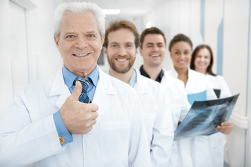 Fototapeta na wymiar Happy professional doctor smiling showing thumbs up