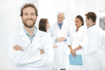 Fototapeta premium Cheerful doctor smiling happily posing in front of the hospital medical team