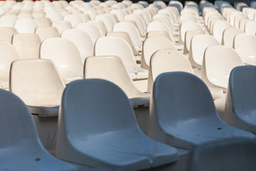 Obraz premium rows of white chairs in the amphitheater with different levels of sun lighting. Stadium, circus, event, theater.