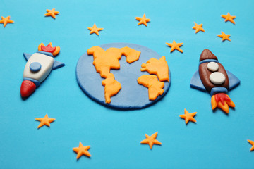 Creative craft plasticine rockets in open space, astronaut dreams. Stars, planet earth. Cartoon art.