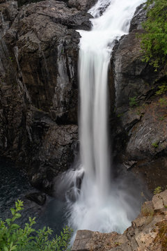 A large single drop waterfall cascading into the river below © Wise Dog Studios