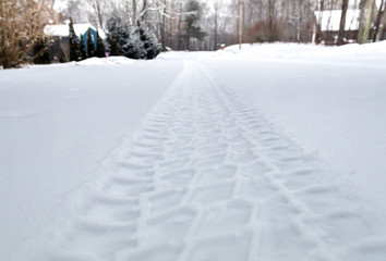 Rugged tire track in freshly fallen snow on a rural street