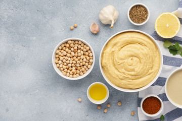 Bowl of hummus and ingredients for cooking. - obrazy, fototapety, plakaty