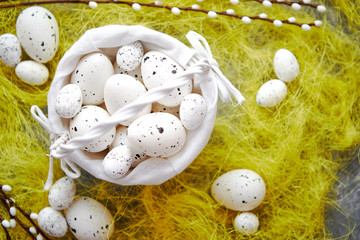 Fototapeta na wymiar Easter white dotted Eggs in the nest and spring yellow grass