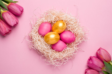 Fototapeta na wymiar Easter pink and gold eggs with flowers on a pink background