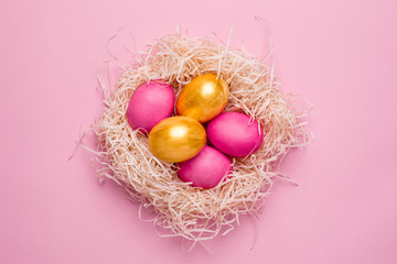 Easter pink and gold eggs on a pink background