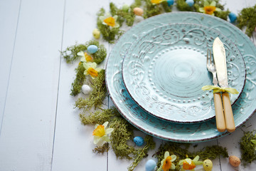Easter table setting with flowers and eggs. Empty decorative ceramic plates