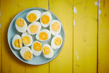 Boiled chicken eggs on a blue ceramic plate. The concept of Easter Holidays