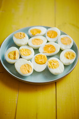 Boiled chicken eggs on a blue ceramic plate. The concept of Easter Holidays