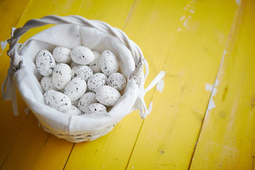 Quail eggs In white wicker basket. The concept of Easter Holidays