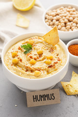Homemade hummus bowl with chips, chickpeas, parsley and paprika