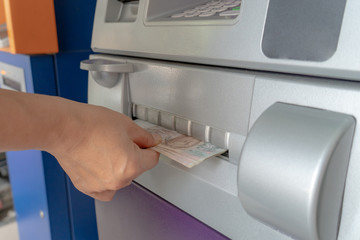 woman's hand holding cash withdrawn from ATM