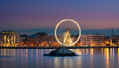Night view of Illuminated giant Ferris wheel on the waterfront of Bari, region of Apulia, Italy....