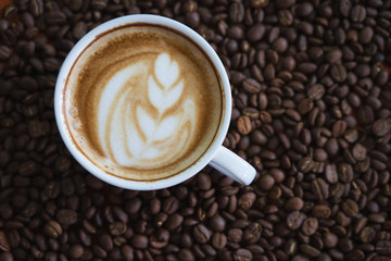 white coffee mug.  Coffee is a latte. table on the wooden table in vintage style, taken from the top view, see the froth of milk foam.