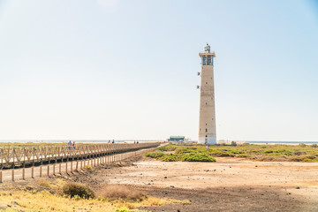 Lighthouse and wooden bridge leading to the beach in Morro Jable, Fuerteventura, Spain