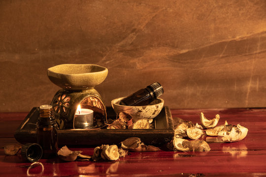 Aroma lamp with essential oil and potpourri on wooden table background.
