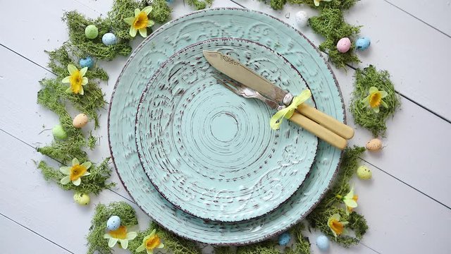 Easter table setting with flowers and eggs. Empty decorative ceramic plates