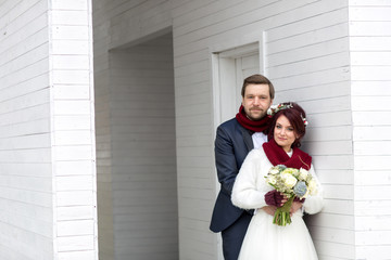 Beautiful bride and handsome groom with red neckcloth posing outdoor