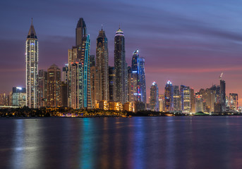 Fototapeta na wymiar Dubai Marina skyscrapers in the illuminations and their reflection in the water