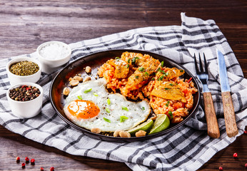 Grilled chicken meat with groats and fried egg on wooden table