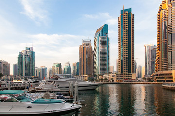 Fototapeta na wymiar DUBAI, UAE - FEBRUARY 2018: View of modern skyscrapers shining in sunrise lights in Dubai Marina in Dubai, UAE