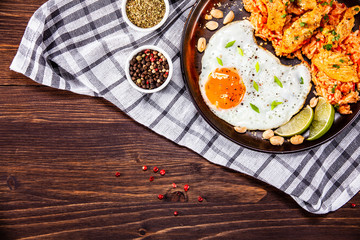 Grilled chicken meat with groats and fried egg on wooden table