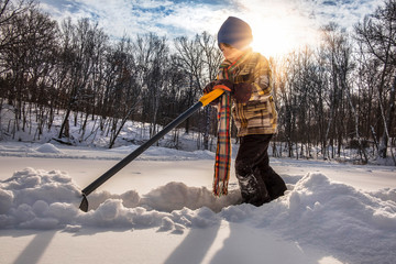 Young boy shoveling lots of snow