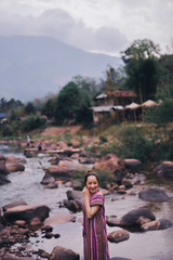portrait of asian women in lanna uniform from thailand north in outdoor mountain and nature with river small in concept relaxing