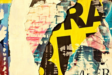 Old grunge ripped torn vintage collage colorful street posters creased crumpled paper surface...