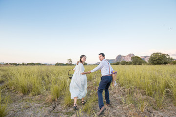 Couple of love running together in green field