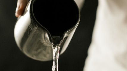 Cook pouring water from a jug in the kitchen