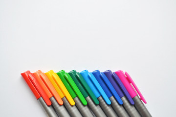 Set of colorful pens, exactly lying diagonally in the bottom side of the photo with copyspace
