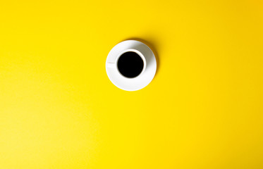 Cup of coffee drink on yellow background, top view