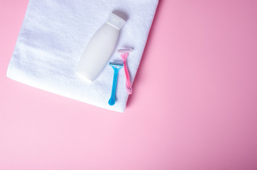 White towel, bottle cream, lotion, razor, soft beauty on pink background, top view