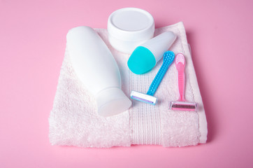 Obraz na płótnie Canvas Pink towel, jar cream, lotion, razor, roller deodorant soft beauty on pink background