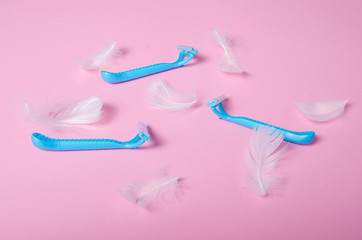 razor, white feather soft beauty on pink background, top view