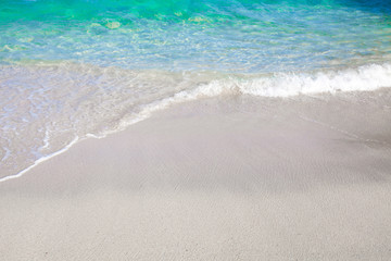 Soft blue ocean wave on clean sandy beach