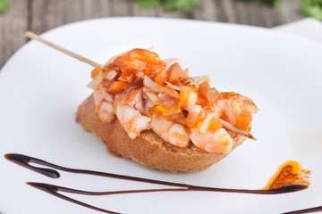 Brocheta de gambas sobre pan
