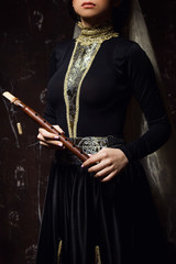 Young woman in armenian national dress with national musical instrument duduk in hands