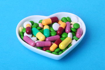 colorful assortment pills and capsules on plate.