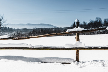 Fototapeta premium wooden fence covered with snow in carpathian mountains