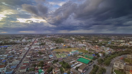 Fototapeta premium Aerial view above city of dark clouds moving with rain storm background, Ban Pong City, Ratchaburi, Thailand.
