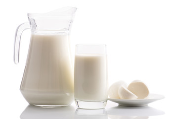 milk in a jug and glass and mozzarella cheese on a white background isolated