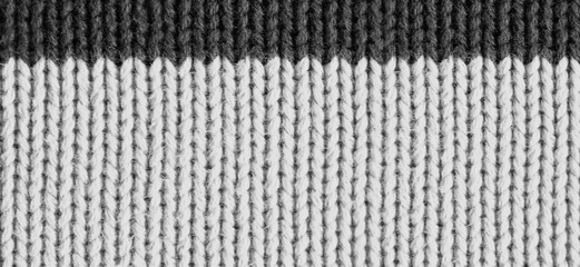Texture of knitted wool fabric. Woolen cloth. Striped warm knitting sweater. Background for wallpaper and other elements of your design. Horizontal orientation.
