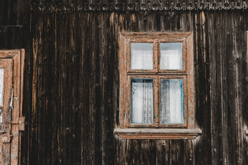 weathered aged brown wooden house with window