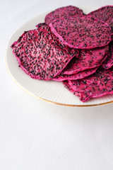 Purple dried dragon fruit on white plate on isolated on white background for graphic purpose with empty text copy space