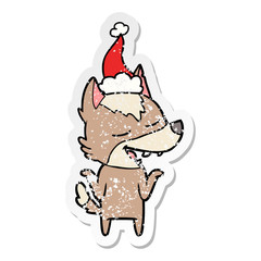 distressed sticker cartoon of a wolf laughing wearing santa hat