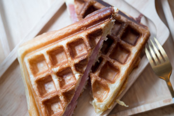 Waffles ham cheese sandwich in wooden plate