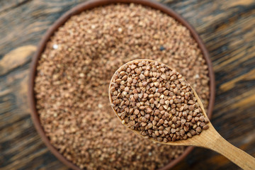 wooden spoon of fried buckwheat on a plate background