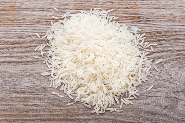 Thailand rice scattered on a wooden surface.
